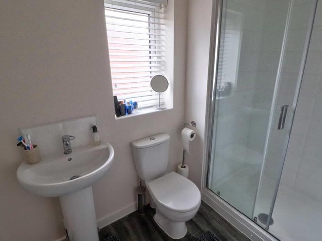 The en suite to the main bedroom features a double shower and a two-piece white suite, comprising hand wash basin and WC. The wet areas are tiled, while the wood-effect, cushioned flooring is a nice touch.