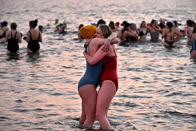 These two women hug to keep warm after braving the cold waters,  (Photo by Jeff J Mitchell/Getty Images)
