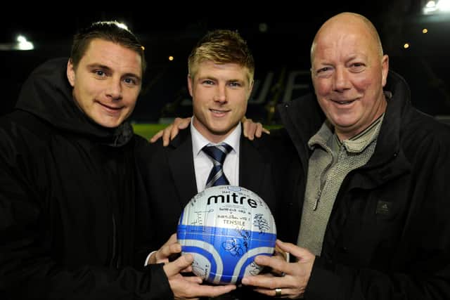 Hat-trick hero Neil Mellor shares a moment with the matchball, his former Owls player dad Ian and his brother Simon (left).