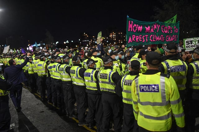 Police officers escort an Extinction Rebellion protest outside the COP26 summit.