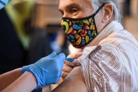 A member of the public receives the Oxford/AstraZeneca Covid-19 vaccine (Photo by OLI SCARFF/AFP via Getty Images).