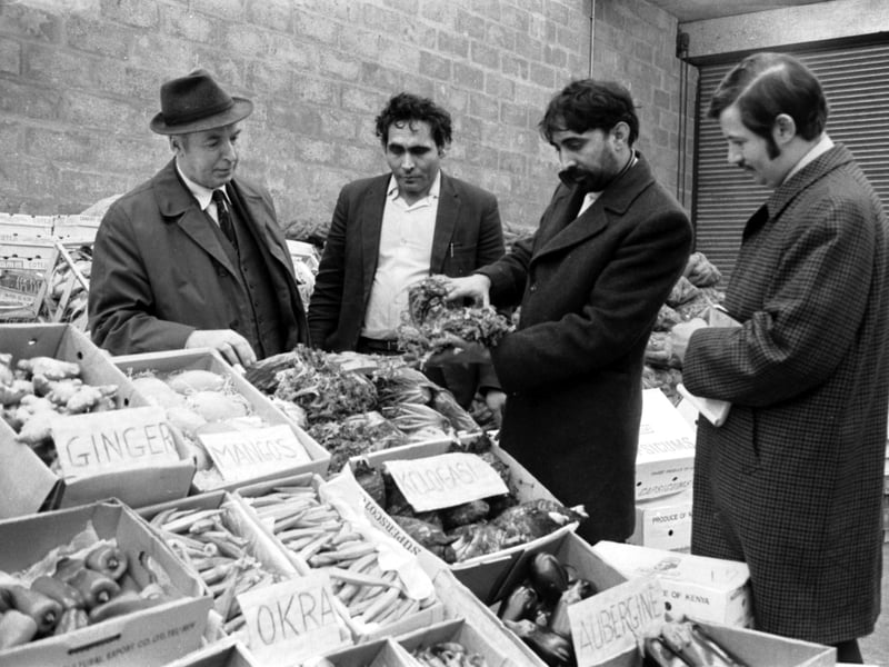 Asian and European traders explain the new'exotic' fruits, vegetables and spices (okra, ginger, mangoes, aubergine) on sale at the fruit market in Glasgow in December 1971.