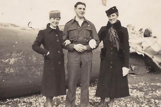 Sgt Roger Dickerson poses with two local women next to the wreckage of the crashed Halifax bomber after his liberation by Allied troops