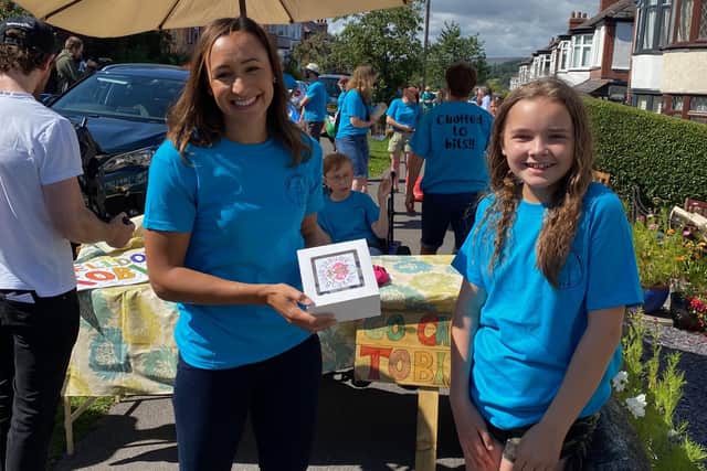 Alana Habergham-Rice presenting her hero, Jess Ennis, with some of her cakes at a recent charity event in Sheffield