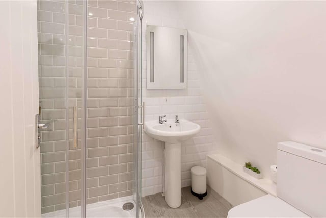 The shower room  has a contemporary look with contrasting tiling
