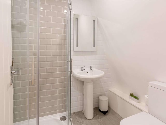 The shower room has a contemporary look with contrasting tiling