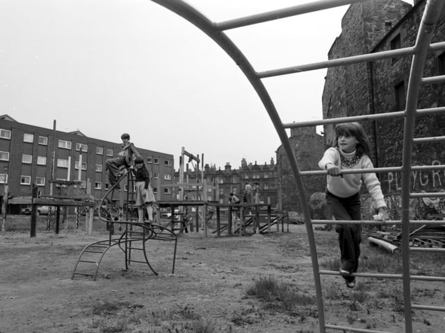 Children playing in an adventure playground in a run-down area of Leith in June 1978. A little girl on the bars.