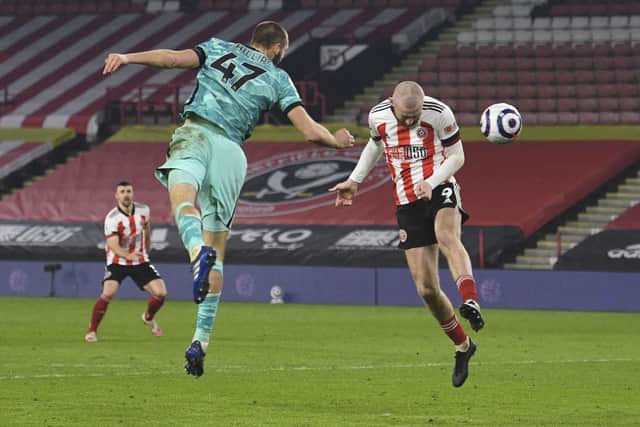Sheffield United's Oliver McBurnie's header goes just wide of the goal as he jumps with Liverpool's Nathaniel Phillips, left, during the English Premier League soccer match between Sheffield United and Liverpool at Bramall Lane stadium in Sheffield, England, Sunday, Feb. 28, 2021: Oli Scarff, Pool via AP