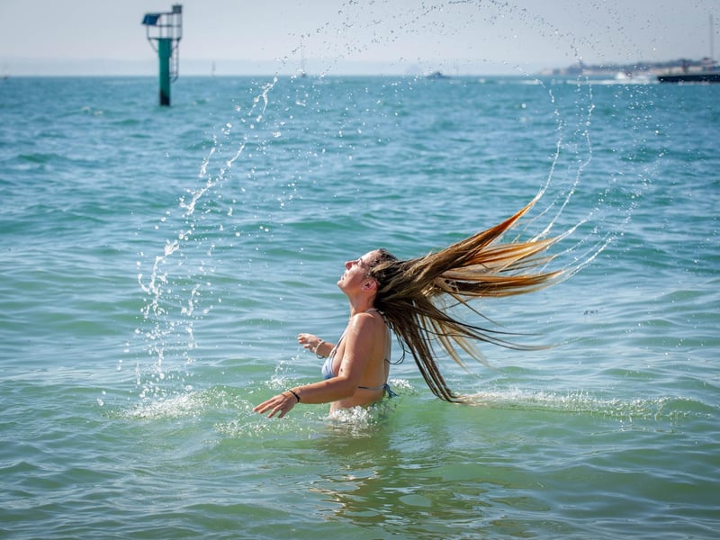 Lucy Wright having cooling her head in the sea at the Hot Walls in Old Portsmouth. Picture: Habibur Rahman