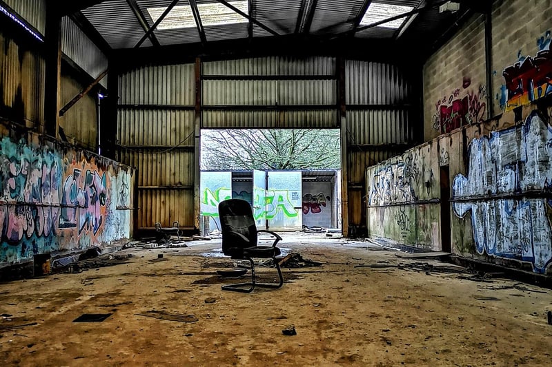 A lone chair remains in the graffiti-strewn interior.