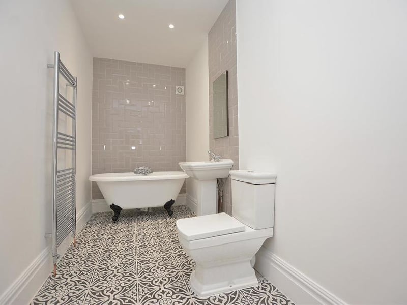 A large family-bathroom that perfectly harnesses the charming, original style of the house, while adding a modern twist. At the heart of it is a free-standing bath with separate shower handset, plus a hand basin, low-flush WC and a chrome, heated towel-rail.
