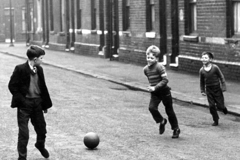 Youngsters playing football on a terraced street in Attercliffe, Sheffield, during the 1960s