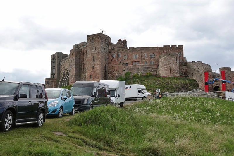 Production vehicles line up near the entrance to Bamburgh Castle.