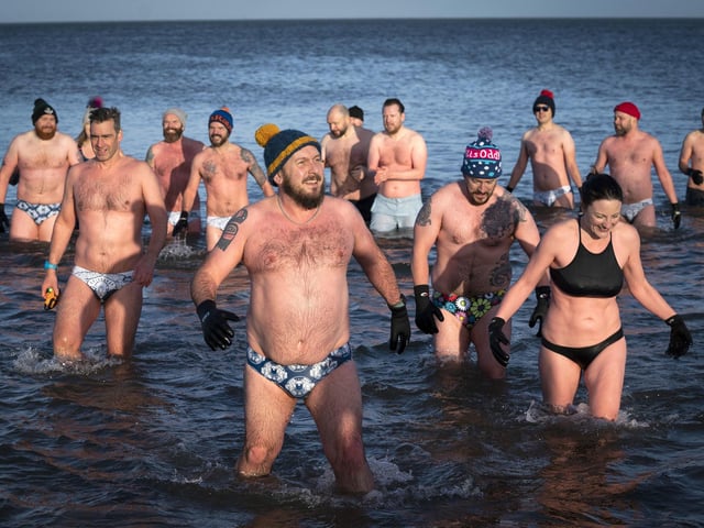 People swim and take a dip in the Firth of Forth at Portobello Beach in Edinburgh on New Year's Day. Picture date: Saturday January 1, 2022. PA Photo. Photo credit should read: Jane Barlow/PA Wire