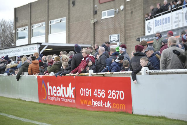 Supporters watch the ball as it leaves the pitch.