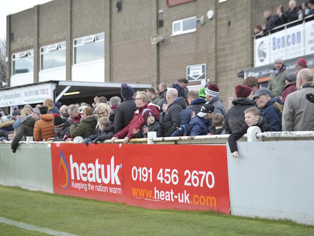 Supporters watch the ball as it leaves the pitch.