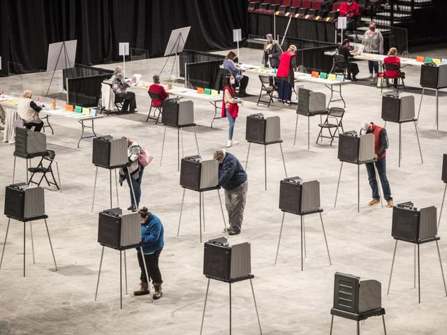 Voters fill out and cast their ballots at the Cross Insurance Center polling location where the entire city votes in Bangor, Maine.