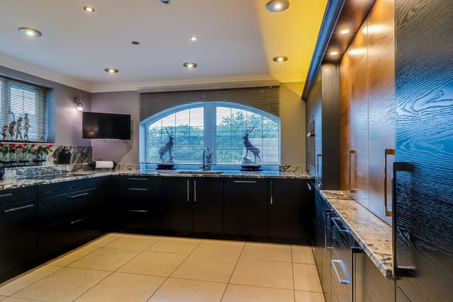 The kitchen has been fitted with contemporary style units and granite worktops, with twin sinks, a champagne cools, built-in oven and an integrated fridge, freezer and dishwasher.