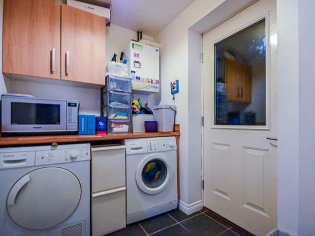 The useful utility room, off the kitchen, provides more valuable space for appliances such as a washing machine and tumble dryer.