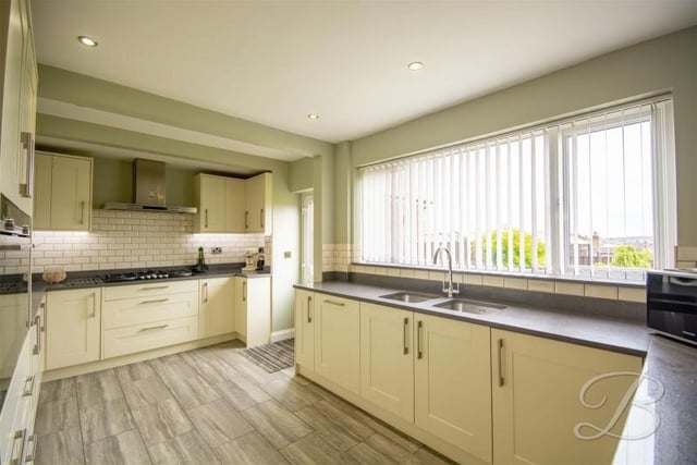 Having a sink and drainer unit set into ample working surfaces benefiting from complementary tiled splashbacks. With laminate flooring and a door providing access outside for convenience.