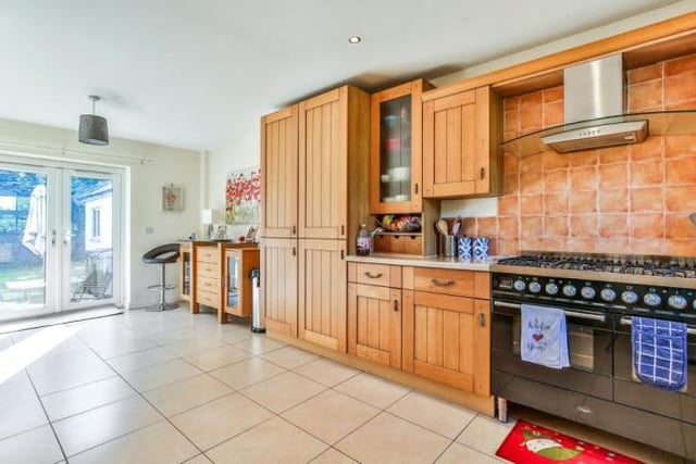 The kitchen has a neat tiled floor, fitted units made from solid wood and a sizeable cooker.