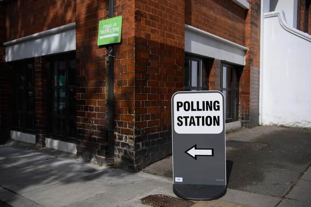 Signs for both a COVID-19 testing station and a polling station (Photo by Leon Neal/Getty Images)