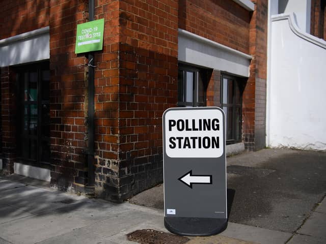 Signs for both a COVID-19 testing station and a polling station (Photo by Leon Neal/Getty Images)