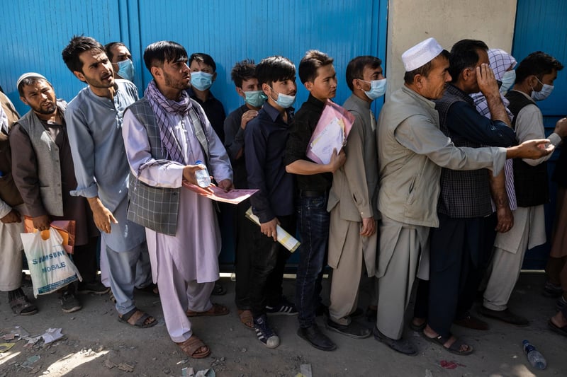 Afghans wait in long lines for hours at the passport office as many are desperate to have their travel documents ready to go