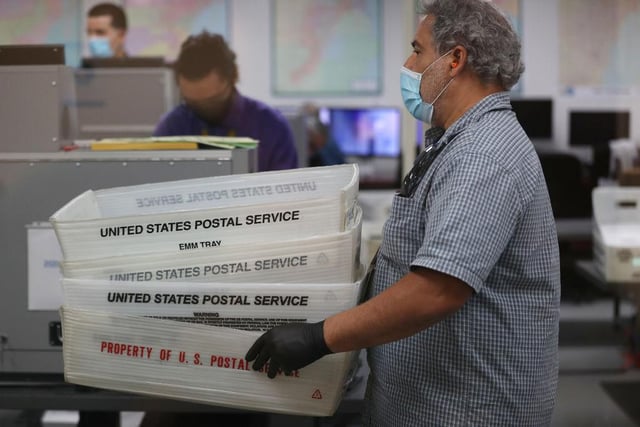Workers at the Miami-Dade County Elections Department work on tabulating the Vote by Mail ballots that have been returned in Doral, Florida.