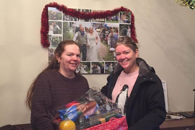500 Together member Kerry Kent, right, presenting Sarah, who lost her husband in a motorbike accident, with £150 of supermarket vouchers and a Christmas hamper courtesy of Morrisons.