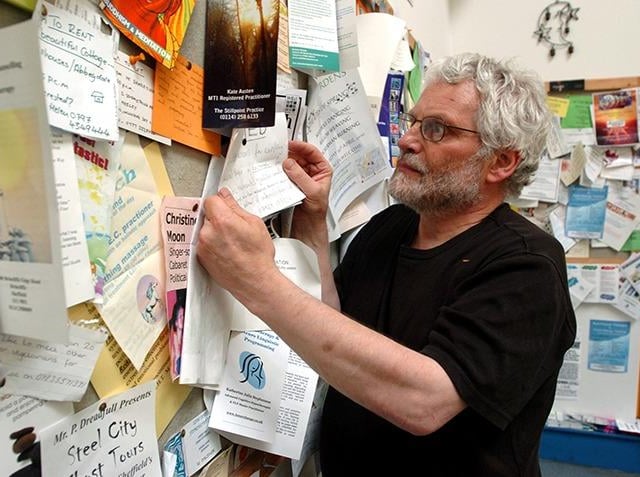 Bill Clark with the Blue Moon Cafe's famous noticeboard, April 28, 2005.  The cafe closed in 2023