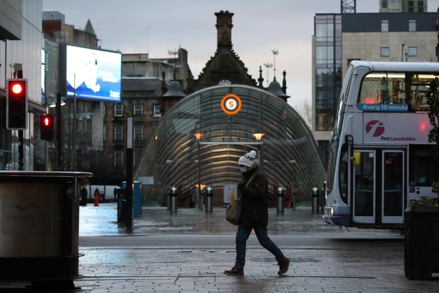 A woman walks past the entrance to the subway station on Buchanan Street, Glasgow