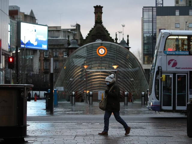 A woman walks past the entrance to the subway station on Buchanan Street, Glasgow