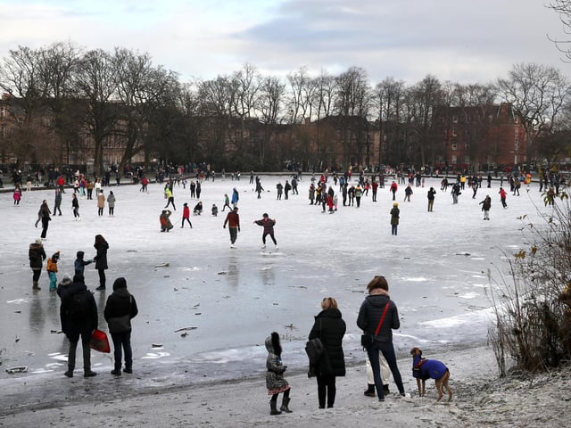 People walk on a frozen pond in Queen's Park in Glasgow. Picture: Andrew Milligan/PA Wire
