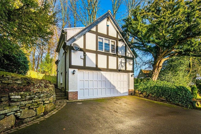 The property has a long driveway leading to a detached garage with an electric door.
