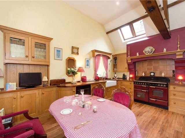 The hand-built breakfast kitchen features solid oak units, a vaulted ceiling, exposed beams and velux windows.