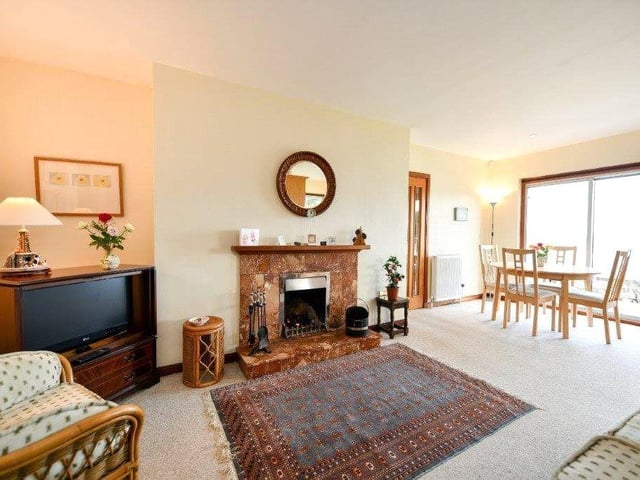 The open plan sitting room has a dining area and sliding doors that lead out to the beach.