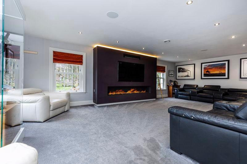 The spacious dual aspect sitting room features a log ribbon gas fire and inset wall-mounted TV point.