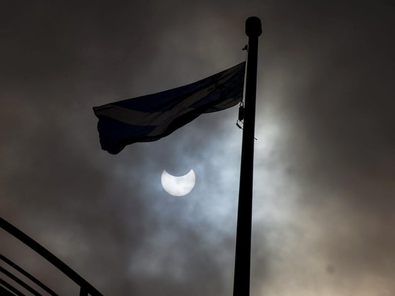 Experts advised looking safely at the sun just after 11am in order to see the eclipse at its peak. Here is another shot of it from Princes Street gardens in Edinburgh as a Saltire flies below it.