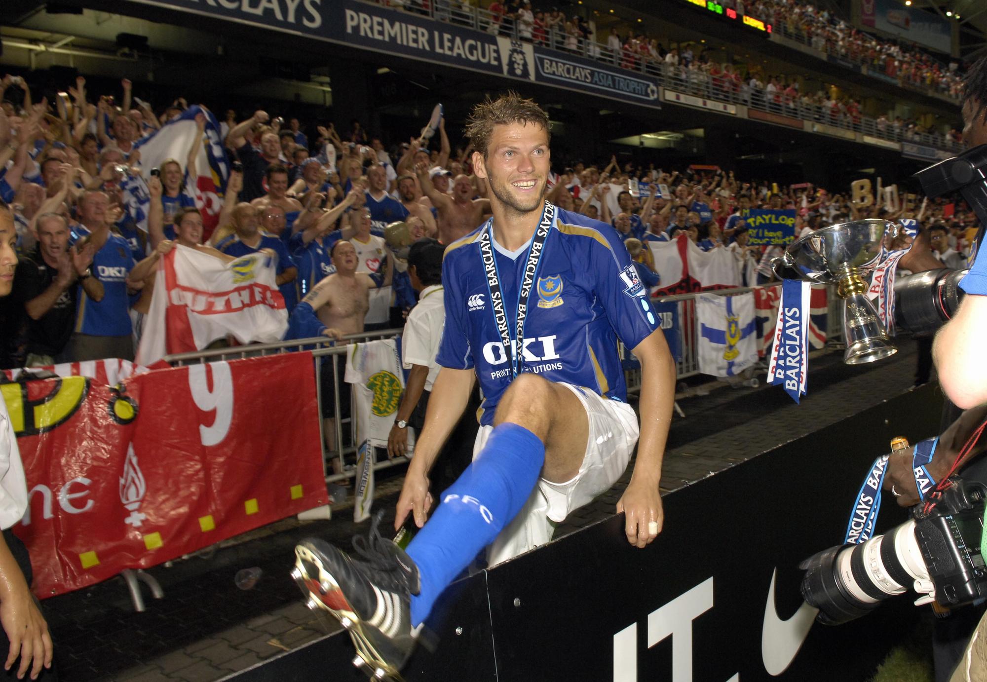 Hermann Hreidarsson jumps the fence to celebrate with the Pompey fans after the Blues' final victory against Liverpool on penalties.
