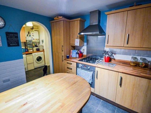 Let the cat lead the way from the practical kitchen, through the archway entrance, into the utility room.