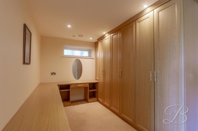 A carpeted dressing-room, just off the master bedroom. It has space for additional storage and fitted furniture.