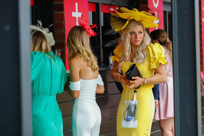 A ticketholder bringing sunshine to the event with a glowy yellow gown and stylish fascinator.