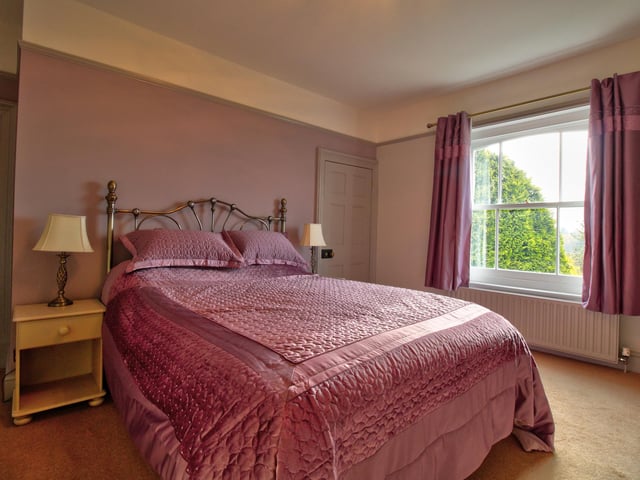 Having a range of fitted cupboards and wardrobes, feature fireplace and sash window.