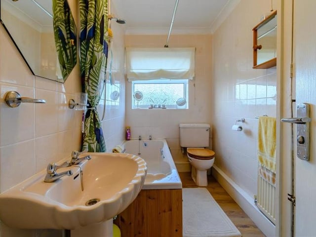 The family bathroom consists of a panelled bath with shower over, a pedestal wash hand basin and low-flush WC. A laminate floor, tiled walls and coving to the ceiling complete the look, while an airing cupboard houses the hot-water cylinder.