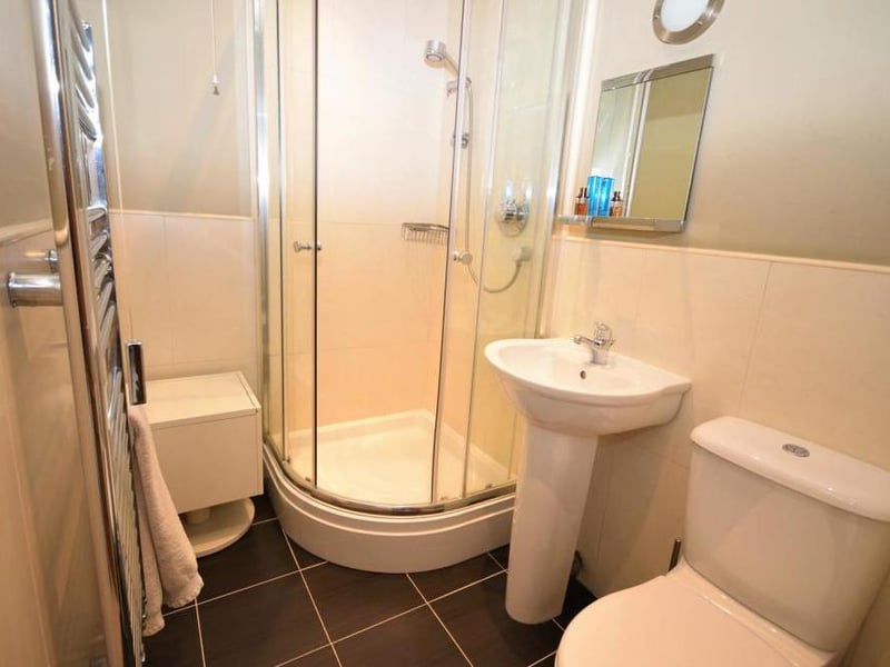 The en suite facilities for the second bedroom. There is a shower cubicle, low-flush WC, wash basin and central-heated towel-rail.