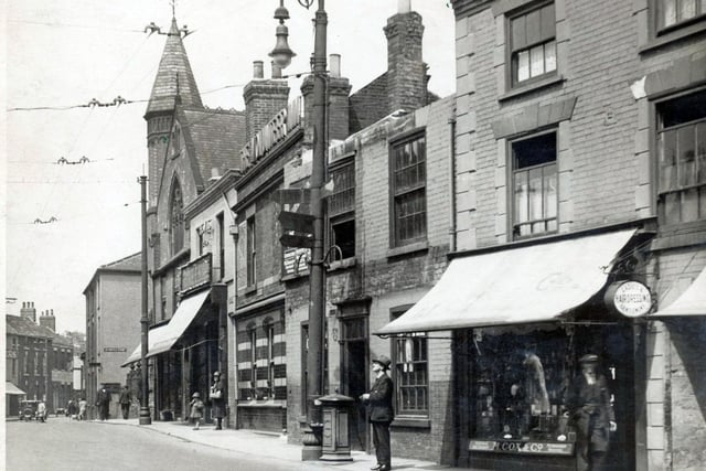With shop awnings and ornate street lights, Holywell Street looked quite different