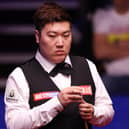 Chinese snooker star Yan Bingtao beat Mark Selby to keep his place in the World Snooker Championship.