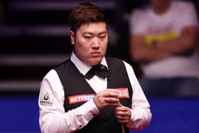 Chinese snooker star Yan Bingtao beat Mark Selby to keep his place in the World Snooker Championship.