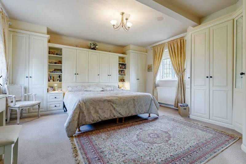 The master bedroom spans the full depth of the property and has fitted wardrobes, bedside tables, shelving, storage cupboards and a dressing table